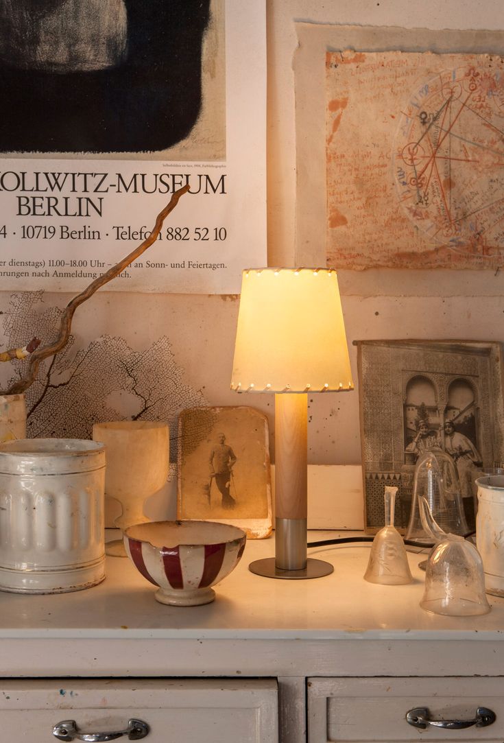 a lamp on a dresser next to some pictures