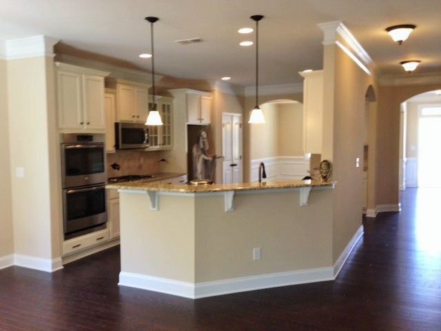 an empty kitchen and living room with hardwood floors