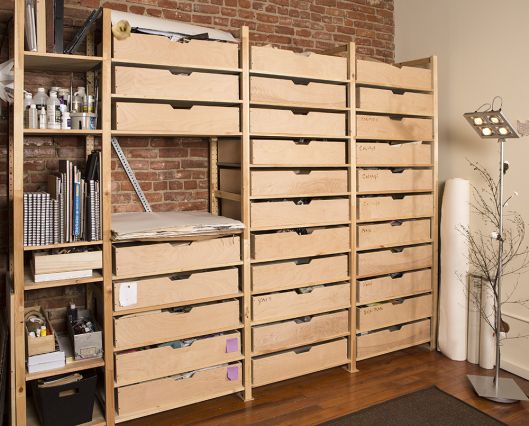 a room filled with lots of drawers next to a brick wall