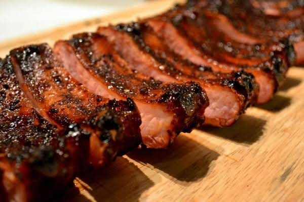 sliced up meat sitting on top of a wooden cutting board