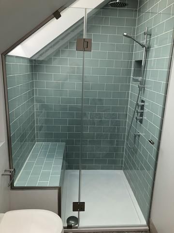 a bathroom with a toilet, shower and skylight in the ceiling area is shown