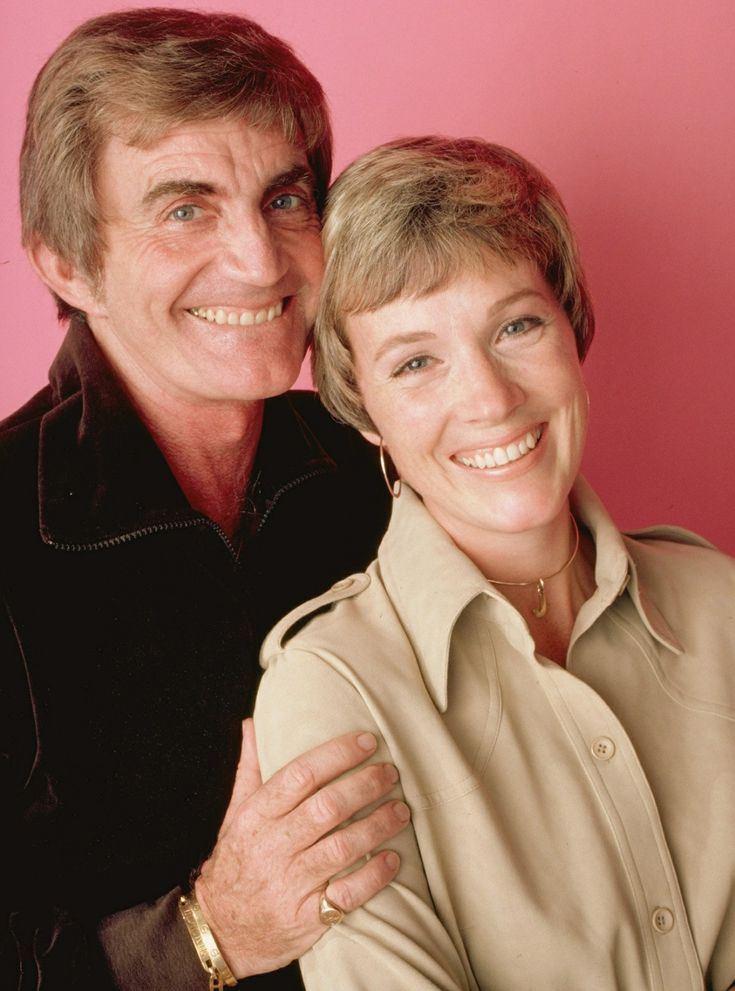 a man and woman are posing for a photo with their arms around each other, smiling