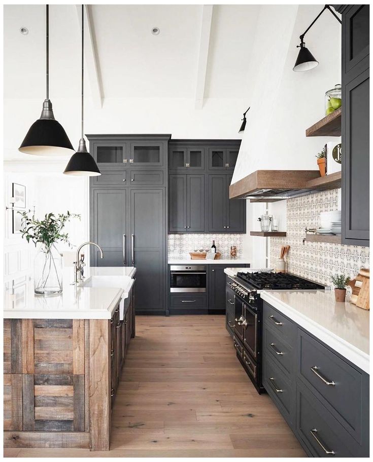 an image of a kitchen setting with dark cabinets and white counter tops, wood flooring