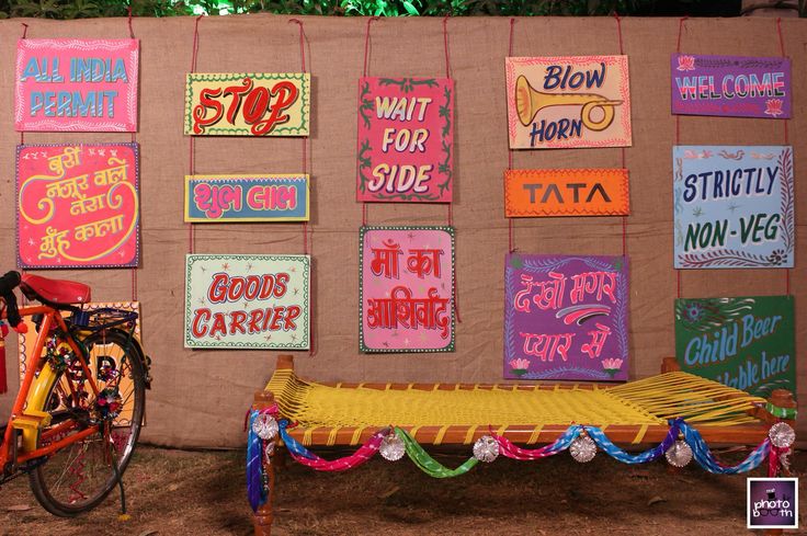 a bike parked next to a wall with posters on it's side and a bed in the foreground