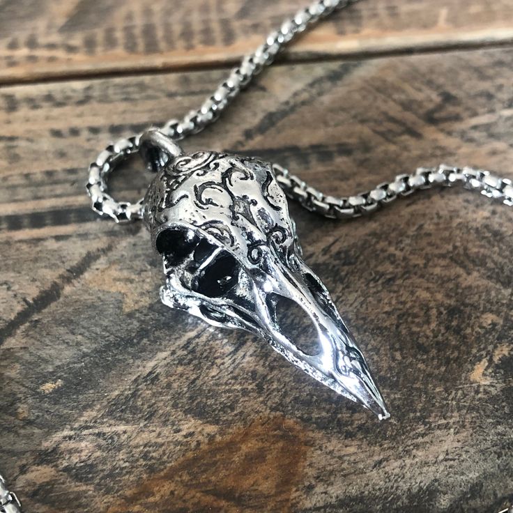 60 cm chain Embrace the shadows with this haunting silver raven skull necklace. Crafted from polished steel , it captures the essence of the enigmatic raven, a symbol of mystery and transformation. Its intricate details and dark allure make it the ultimate accessory for those who dare to delve into the macabre. Wear it as a talisman of the night, a reminder that beauty often lies in the darkness. Raven Skull Necklace, Raven Pendant, Skull Pendant Necklace, Raven Skull, In The Darkness, Skull Necklace, Skull Pendant, The Shadows, The Darkness