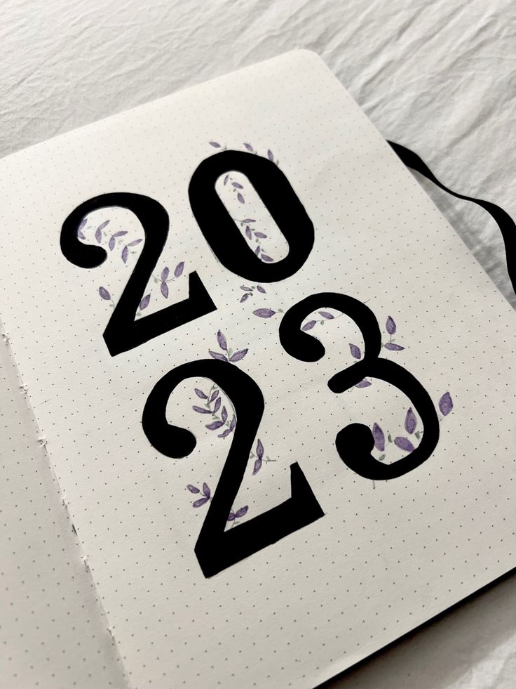 a notebook with the numbers 2012 and 2013 printed on it, next to a pen