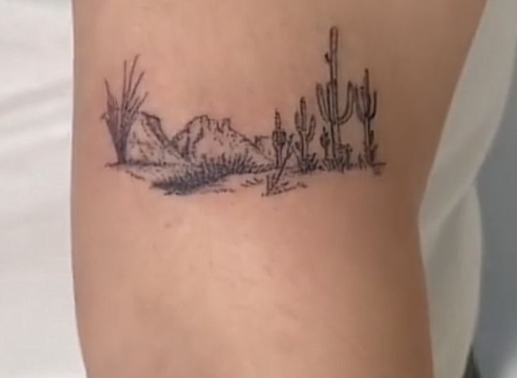 a woman's arm with a small cactus tattoo on the left side of her body