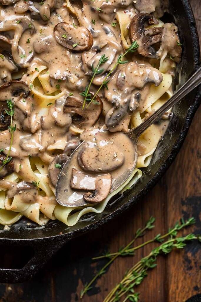 a skillet filled with pasta covered in mushroom sauce