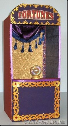 an old fashioned fortune machine is decorated with gold and purple