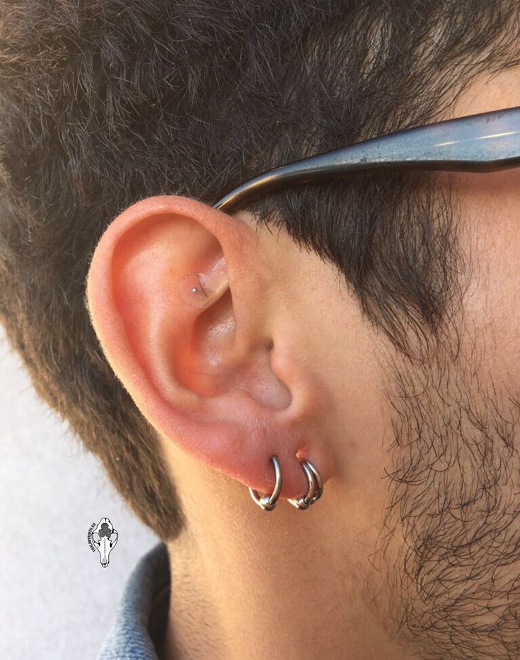 a close up of a person with some piercings on their ears