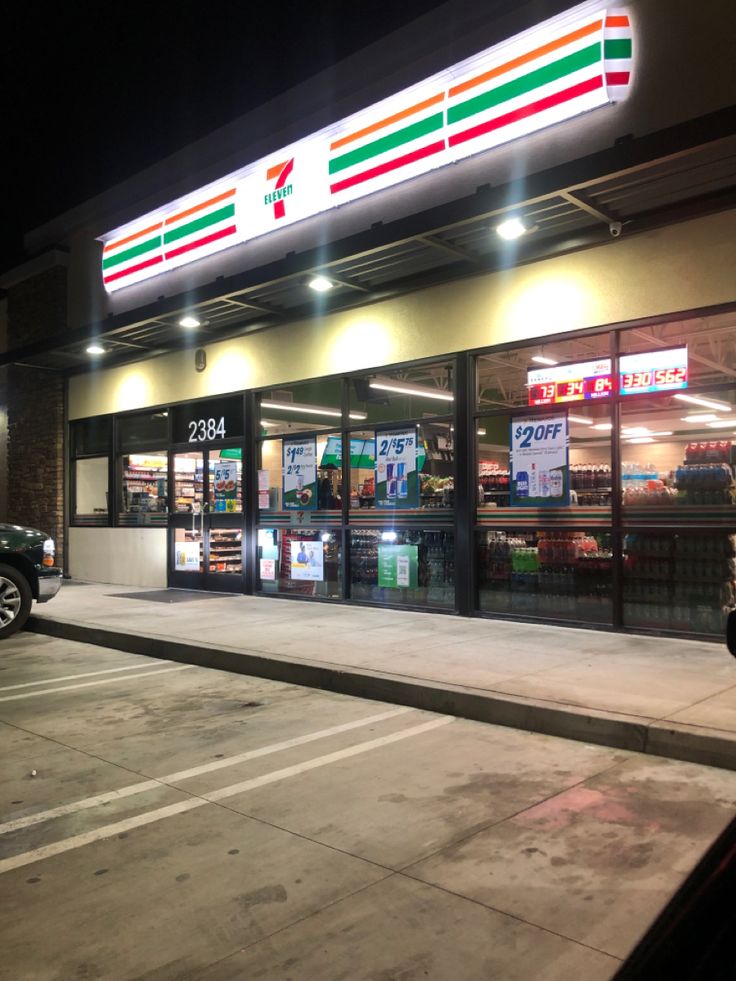 an empty parking lot at night in front of a grocery store with the lights on