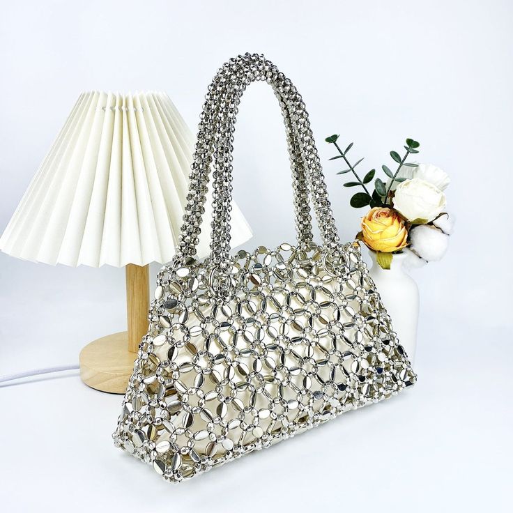 Featuring a hollow exterior adorned with intricate circular patterns, this bag exudes a unique and modern aesthetic that captures attention wherever you go. Its versatile design seamlessly complements a wide range of outfits, making it perfect for various occasions. Crafted from premium quality materials, the Lustrous Handbag exudes luxury and durability, ensuring it stands the test of time. Now available in gold and silver. Modern Double Handle Bag, Chic Silver Handheld Shoulder Bag, Silver Rectangular Elegant Hobo Bag, Silver Elegant Rectangular Hobo Bag, Elegant Silver Rectangular Hobo Bag, Fashion Tote Shoulder Bag With Top Carry Handle, Elegant Silver Hobo Shoulder Bag, Elegant Silver Hobo Bag, Silver Tote Shoulder Bag With Top Carry Handle