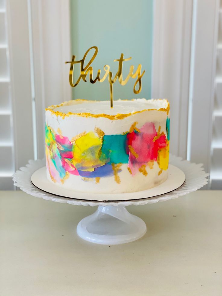 a colorful cake with the word happy on top