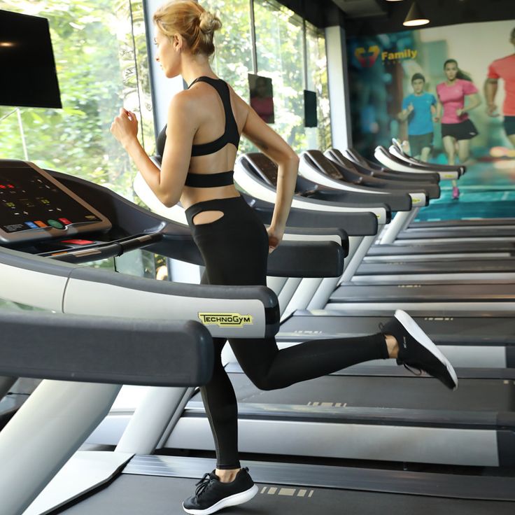 a woman running on a treadmill in a gym