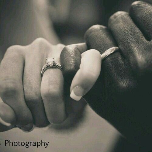 a man and woman holding hands with wedding rings on their fingers in black and white