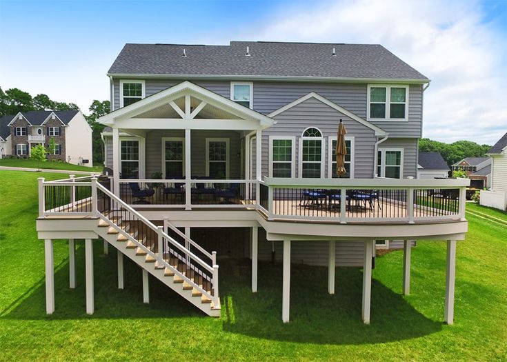 a large house with a deck in the grass