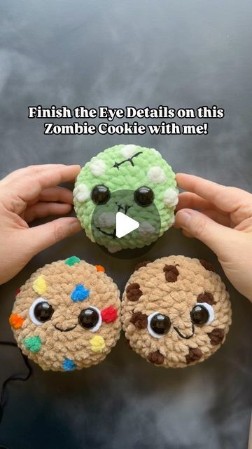 two crocheted cookies with googly eyes are being held by someone's hands