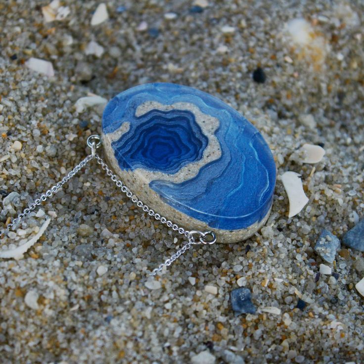 A ring-shaped reef, island, or chain of islands formed of coral The Atoll pendant has been carefully handmade from bonded beach sand, ultramarine or aqua blue resin and metal pigments with a high-gloss polished finish. Two eye screws connect the piece to a fine cable link chain. All metal parts are rhodium plated. Each purchase from BoldB's Aqua Collection will help provide one year of safe water to one person in need through BoldB's support of Water.org, an international nonprofit organisation. Unique Gemstone Jewelry For The Beach, Blue Gemstone Necklace For Beach, Blue Pendant Jewelry For Beach, Blue Gemstone Jewelry For The Beach, Ocean-inspired Blue Pendant Jewelry, Blue Jewelry With Adjustable Chain For Beach, Blue Beach Jewelry With Adjustable Chain, Unique Blue Jewelry For The Beach, Blue Sterling Silver Necklace For Beach