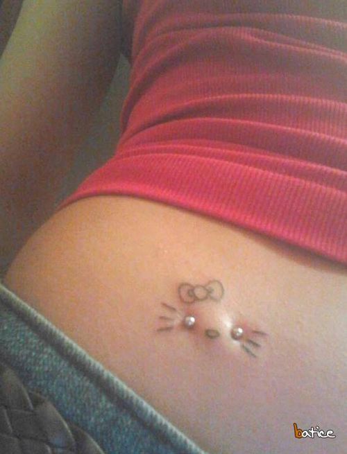 a woman's stomach with a cat tattoo on the lower part of her belly