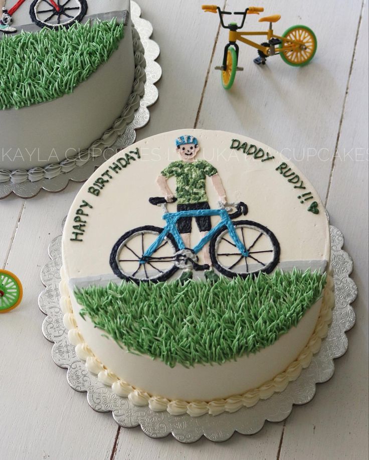 there is a birthday cake with a bicycle on the top and green grass around it