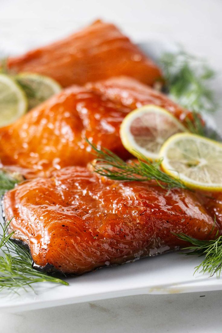 salmon with lemons and dill on a white plate