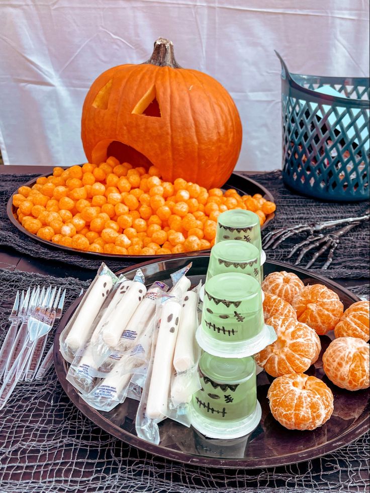 an assortment of candies and pumpkins on a table