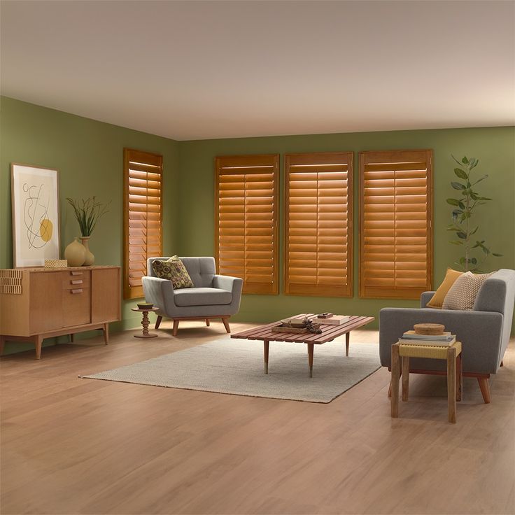 a living room with green walls and wooden shutters