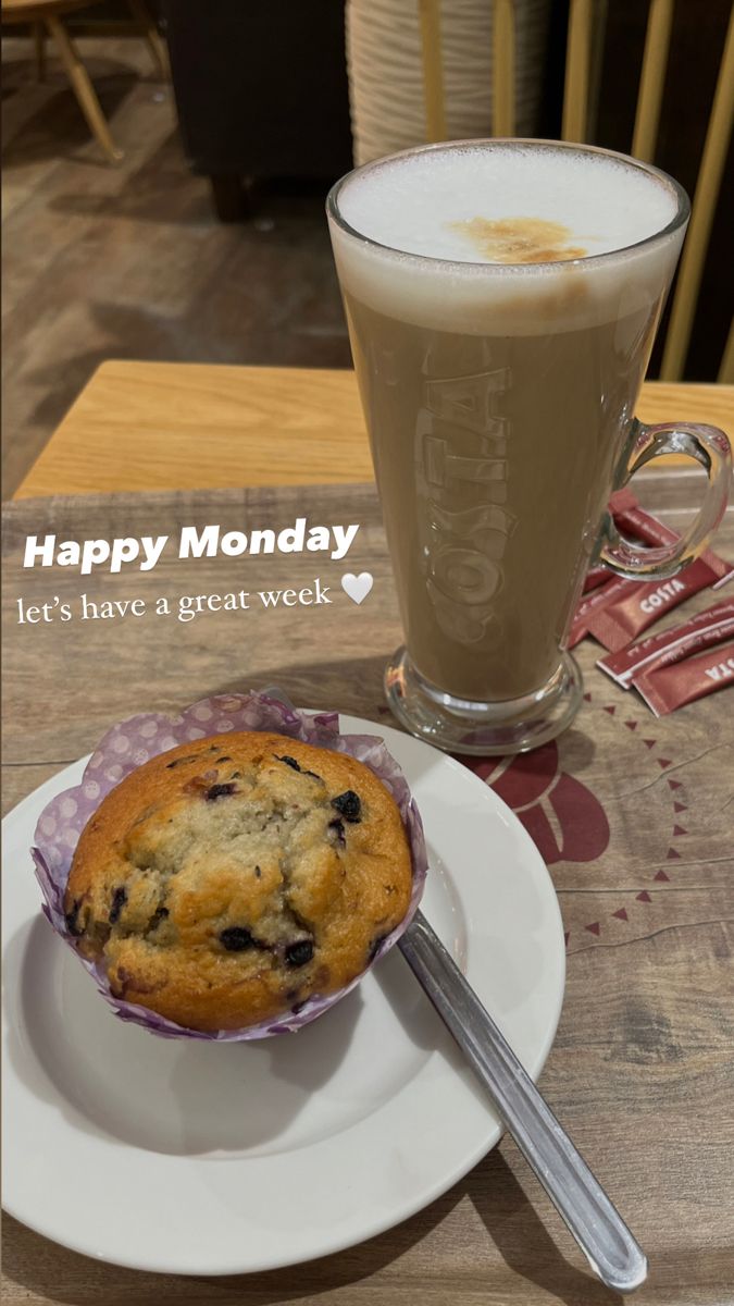 a muffin on a plate next to a cup of coffee and a glass of milk