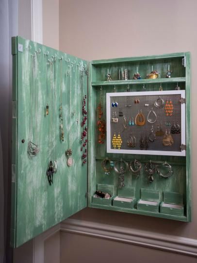 an open green cabinet with earrings on it