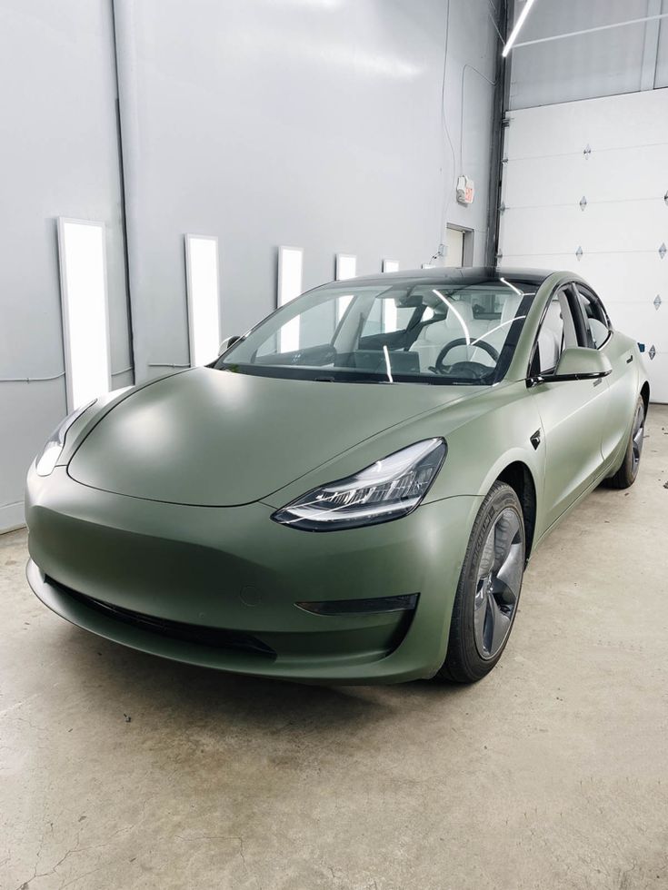 a green car is parked in a garage