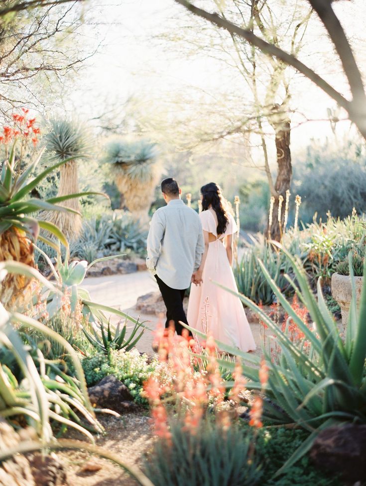 a bride and groom walking through the desert garden at their wedding reception in palm springs, florida