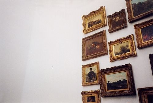 a wall with many framed pictures on it