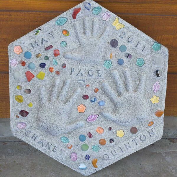 a hand and foot imprint on a cement plaque