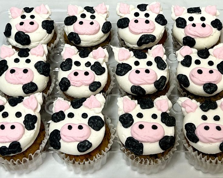 cupcakes decorated with black and white frosting in the shape of cows