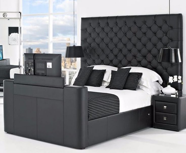 a black and white bedroom with a bed, night stand, nightstands and windows