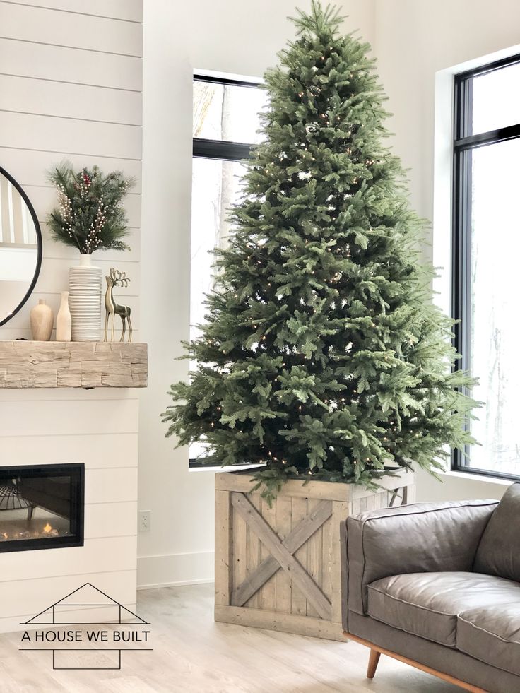 a living room with a christmas tree in the corner and a couch next to it