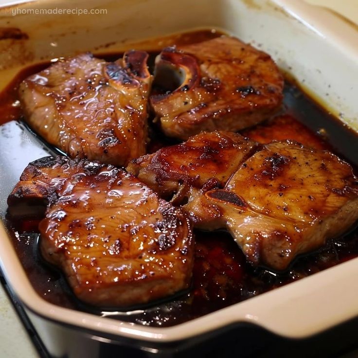 some meat is sitting in a pan on the stove