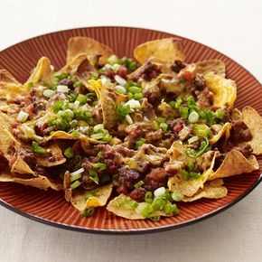 a plate full of nachos with the words game day beef nachos on it