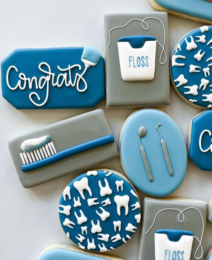 cookies decorated with blue and white icing are arranged in the shape of toothbrushes