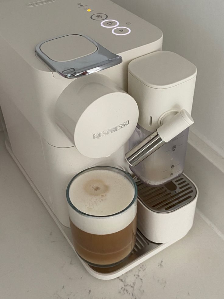 there is a coffee maker with two cups next to it