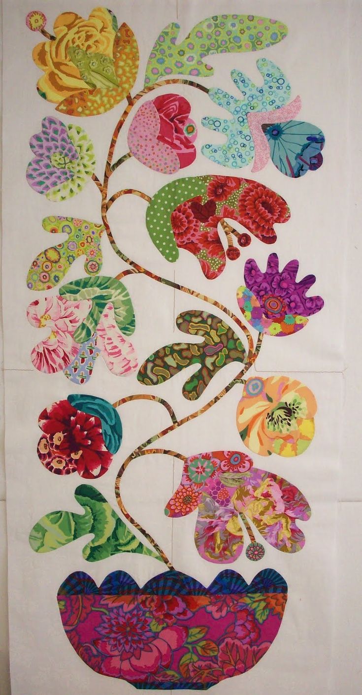 an embroidered wall hanging with colorful flowers in a flower pot on the front and side