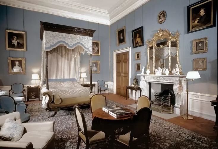 a bedroom with blue walls and pictures on the wall, including a canopy bed in an ornately decorated room