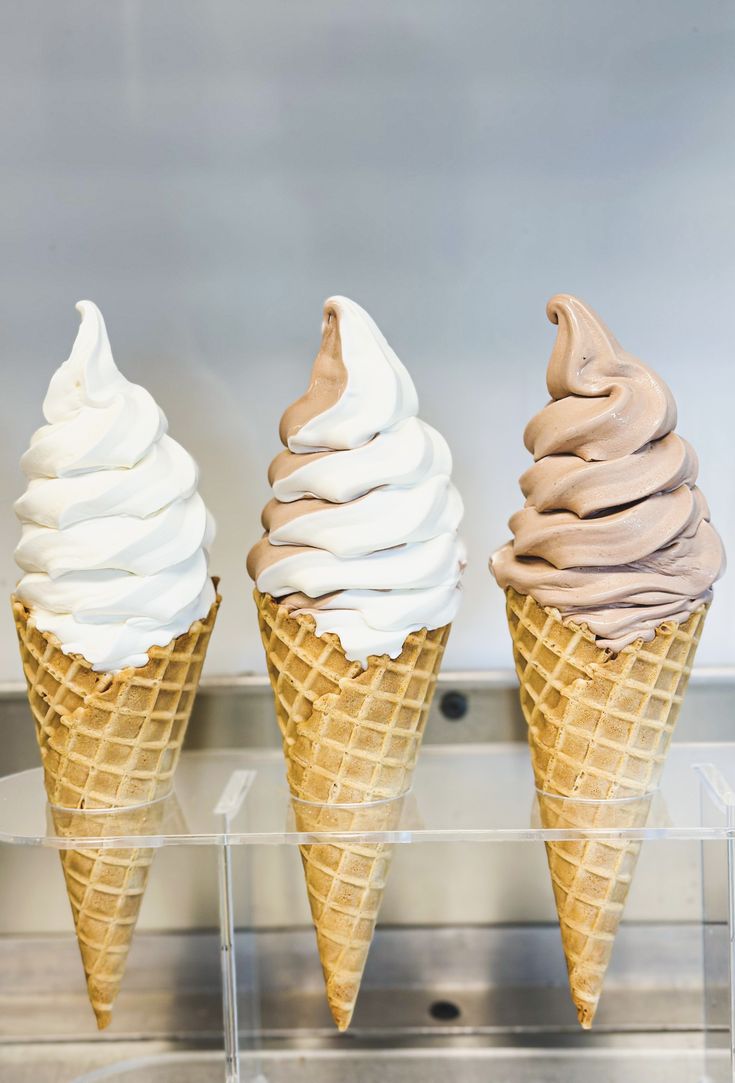 three ice cream cones sitting on top of a counter