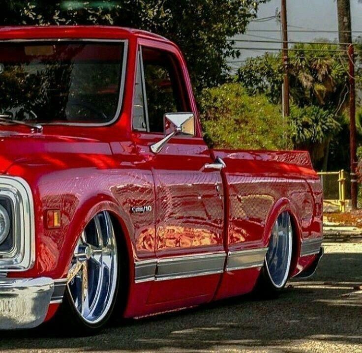 an old red pickup truck parked on the street