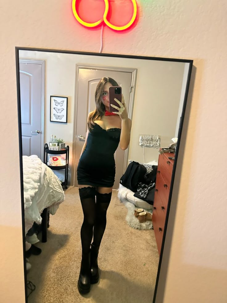 a woman taking a selfie in the mirror with her cell phone and wearing black stockings