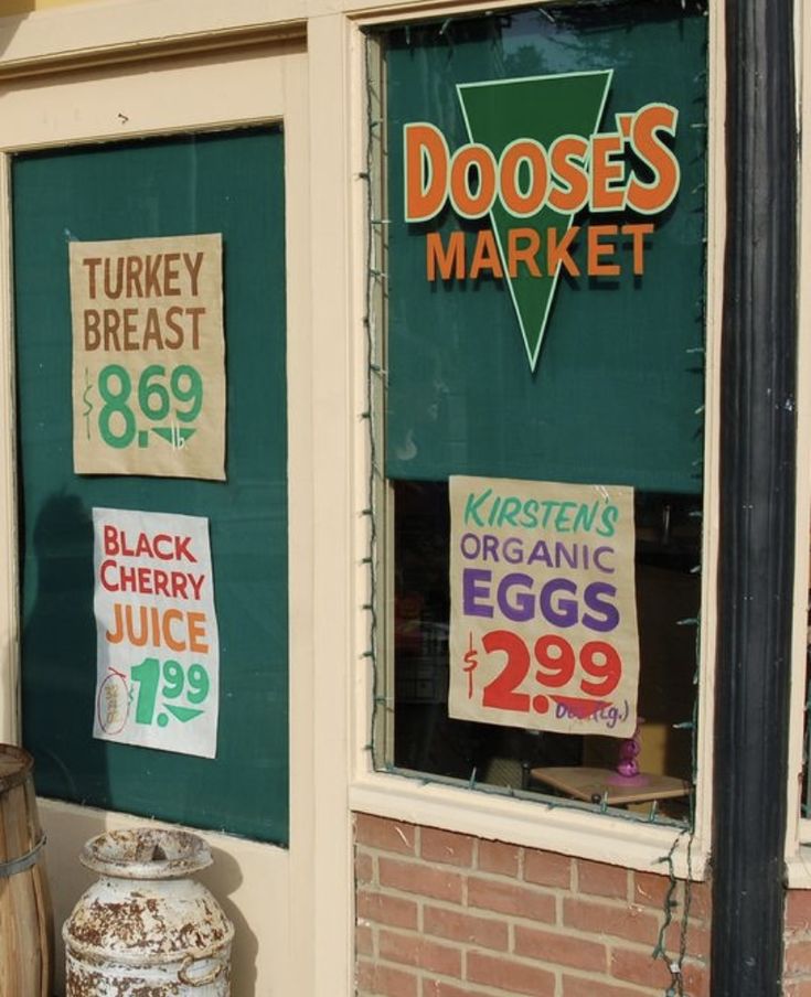 a store front with signs on the window and in front of it that says doeses market