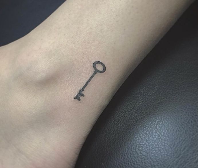 a small key tattoo on the ankle