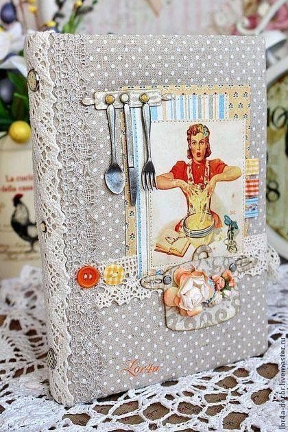 an altered photo album is sitting on a lace doily covered tablecloth with spoons and utensils