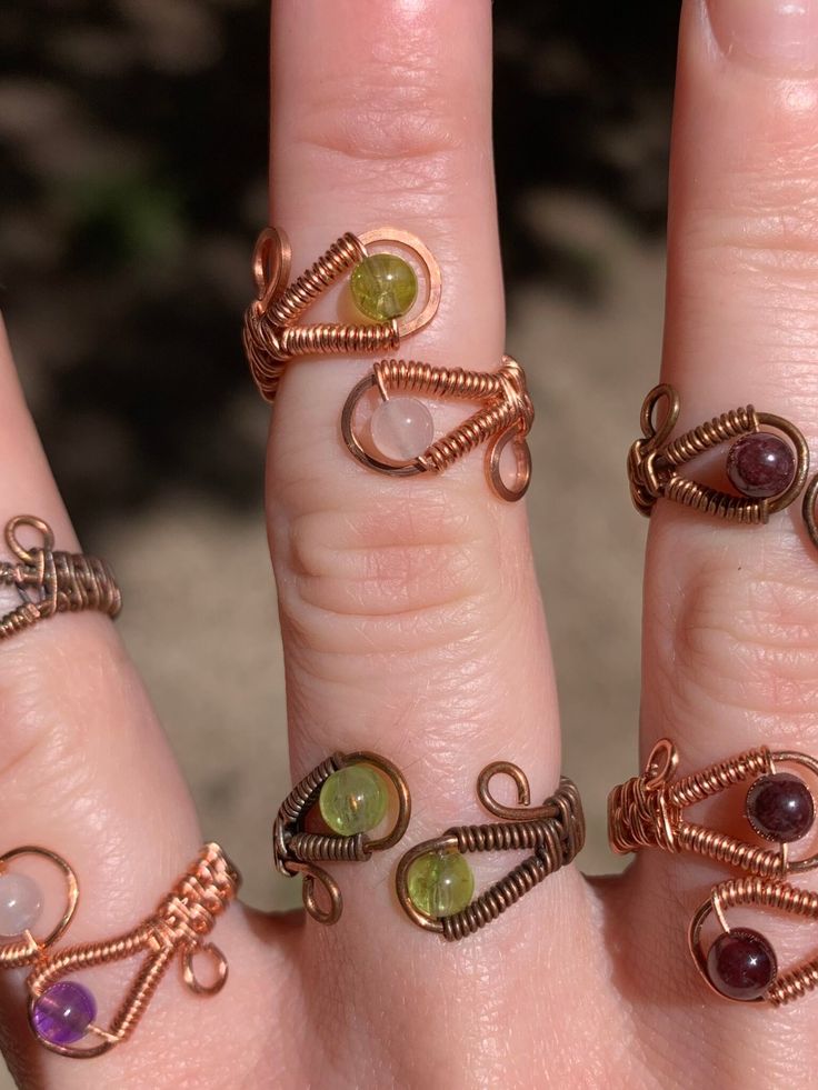 a woman's hand with five different rings on it and one is wearing an amethyst ring