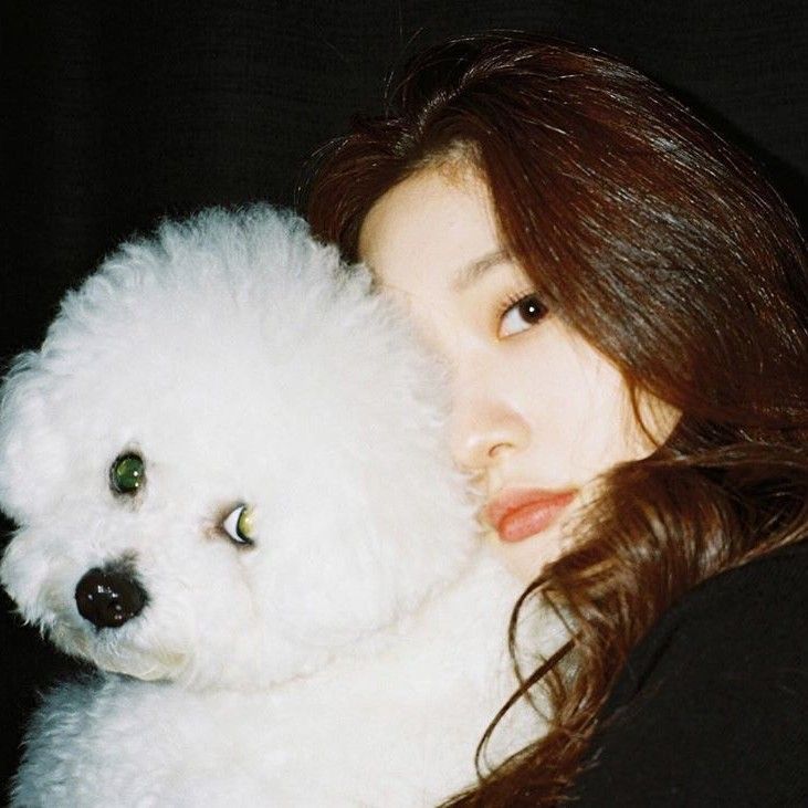 a woman holding a white teddy bear in her arms